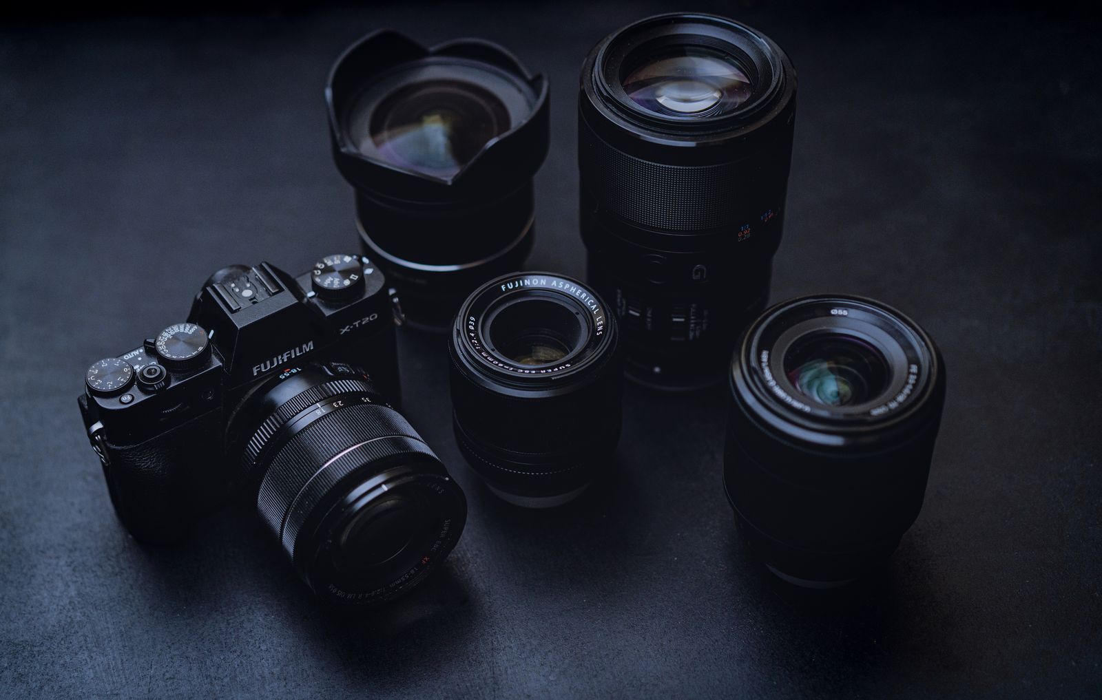Camera body and lenses on a dark surface
